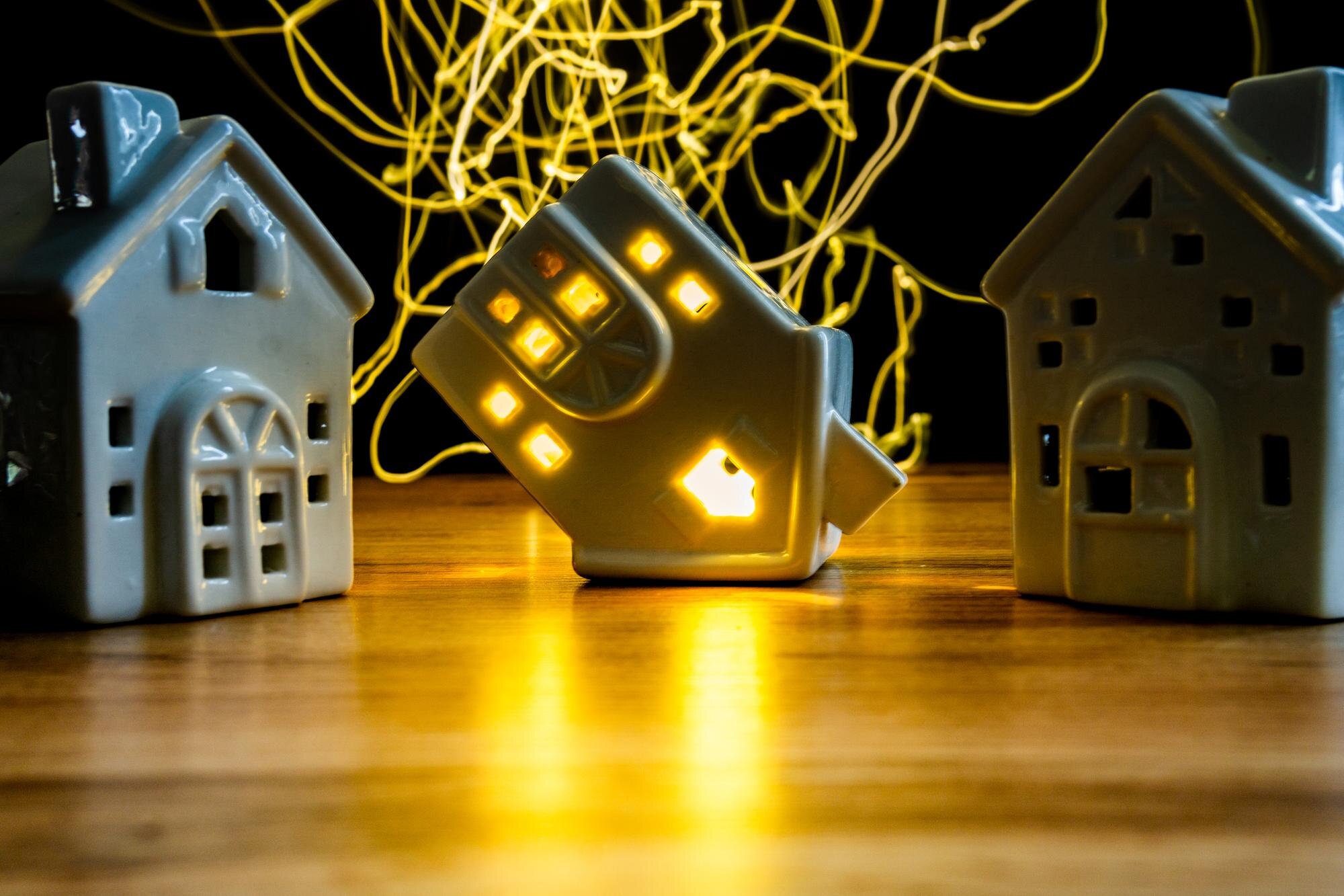 ceramiczny dom na boku koncepcja kryzysu mieszkaniowego jeden dom z włączonym światłem