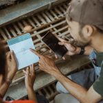 Przedsiębiorca sprawdza książeczkę oszczędnościową i korzysta z telefonu komórkowego na farmie kurczaków