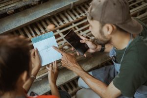 Przedsiębiorca sprawdza książeczkę oszczędnościową i korzysta z telefonu komórkowego na farmie kurczaków