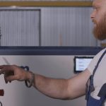 Mężczyzna klika panel sterowania kreatywnego mężczyzny w mundurze i dostosowuje panel w fabryce