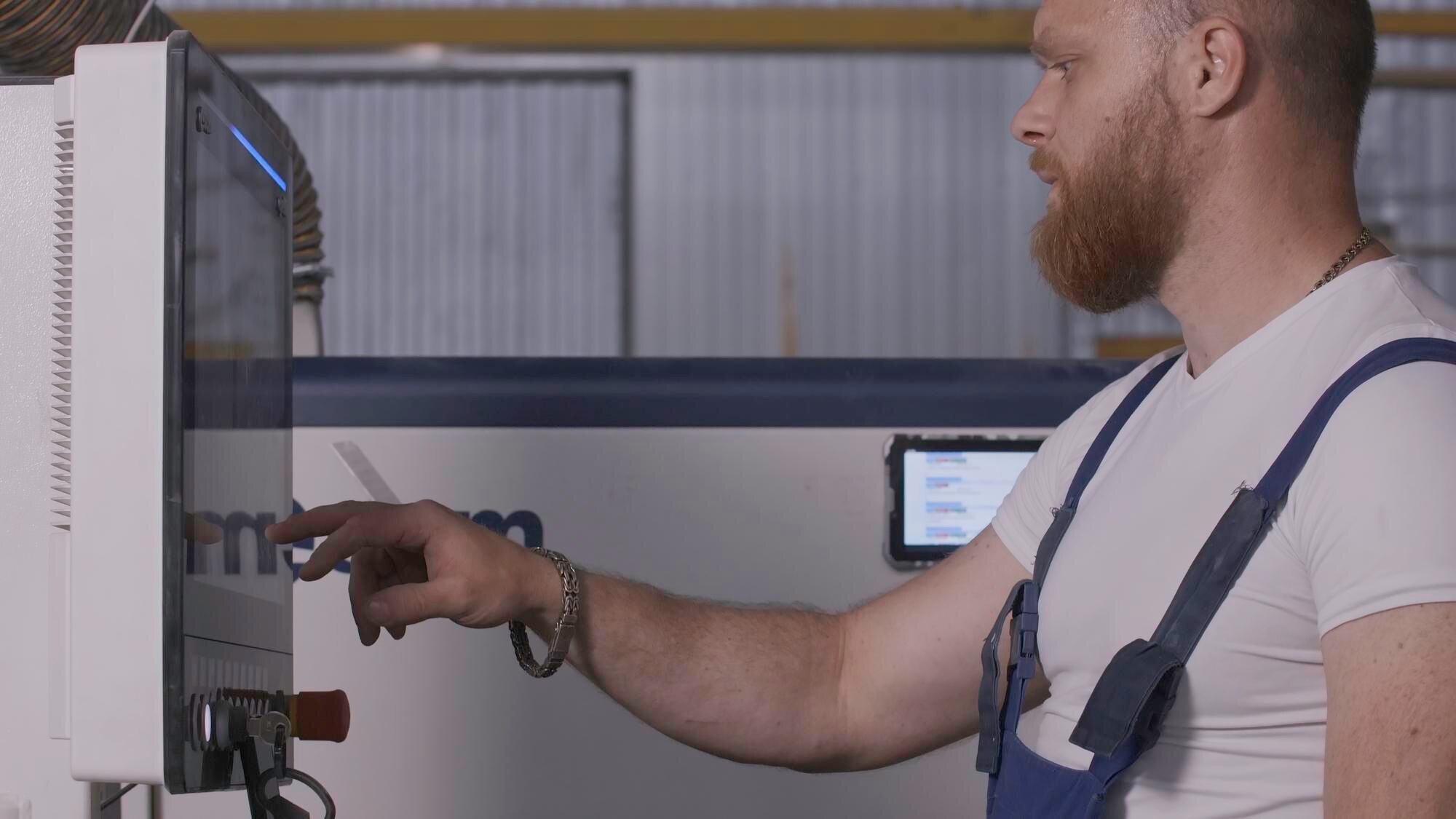 Mężczyzna klika panel sterowania kreatywnego mężczyzny w mundurze i dostosowuje panel w fabryce