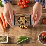 Mężczyzna robiący zdjęcie jedzenia telefonem komórkowym