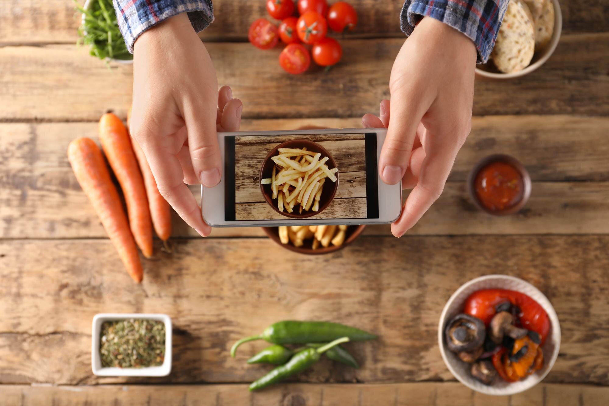 Mężczyzna robiący zdjęcie jedzenia telefonem komórkowym