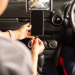 Kobieta ładuje baterię smartfona w samochodzie