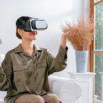 Młoda kobieta używająca gogli wirtualnej rzeczywistości w domu dla najlepszego doświadczenia