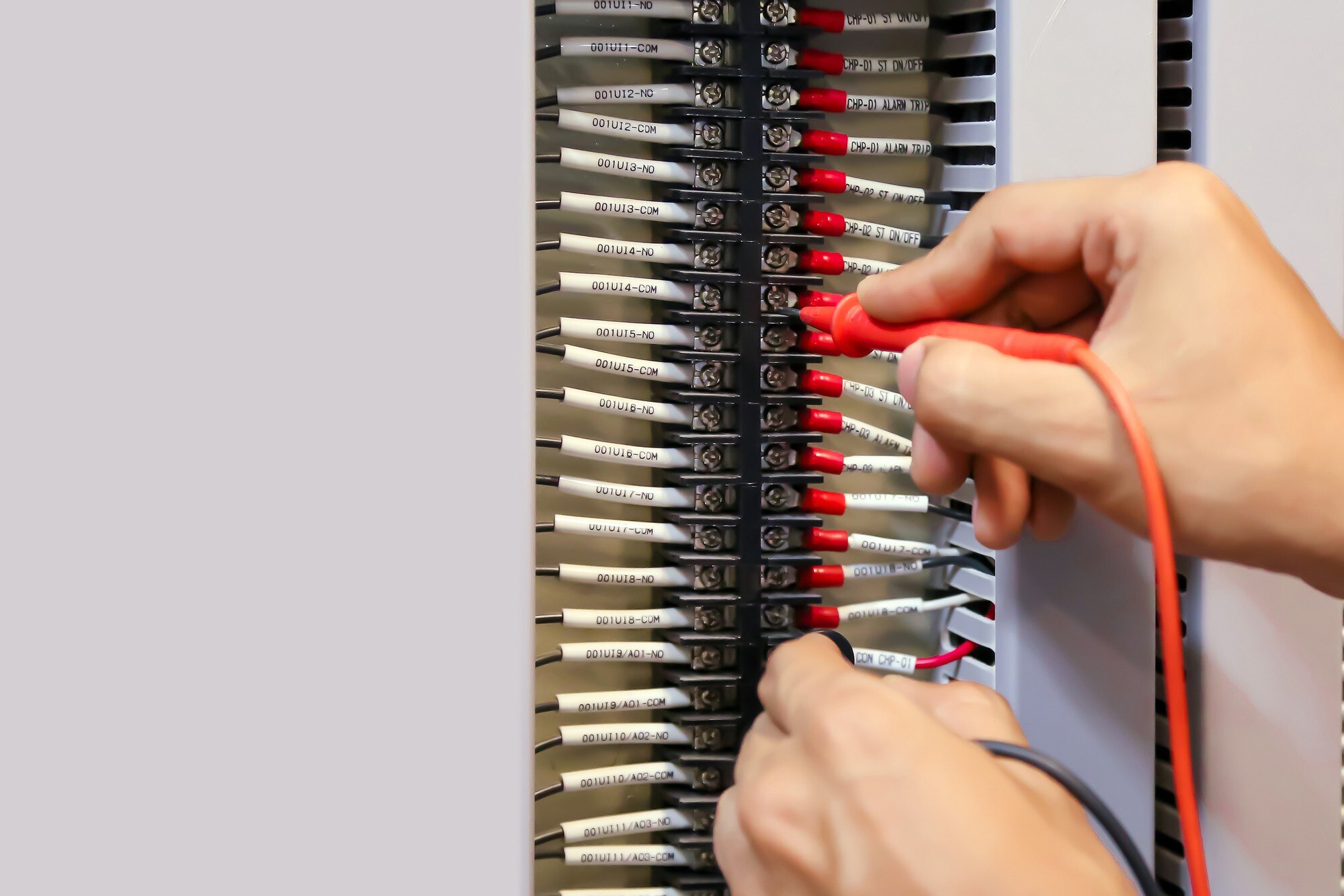 Zbliżenie dłoni elektrotechniki za pomocą pomiaru do sprawdzania energii elektrycznej.