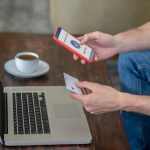 Płatności online. Mężczyzna siedzący przy laptopie i płacący kartą kredytową online