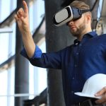 Ujęcie inżyniera trzymającego kask i noszącego gogle VR w nowym budynku. Zmień sposób, w jaki widzisz i doświadczasz świata.