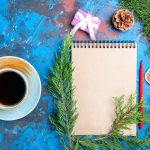 Widok z góry notatnik gałęzie sosny czerwony ołówek filiżanka herbaty na niebieskim tle