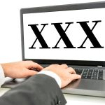 XXX napisane na monitorze laptopa na białym tle. Koncepcja porno.