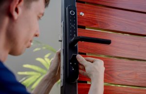 Technik instaluje nowoczesny inteligentny zamek na drewniane drzwi