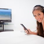 Uśmiechnięta kobieta słucha muzyka w żywym pokoju