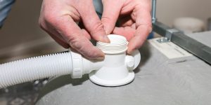 Instalacja wanny. Pracownik robi zapięcie. Naprawa konserwacyjna w mieszkaniu. Proces renowacji.