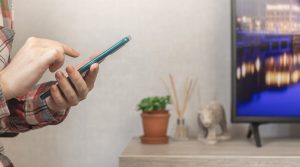 Kobieta za pomocą smartfona w domu, wysyłanie wiadomości lub przeglądanie sieci społecznościowych koncepcja zdjęcie w tle