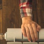 Ręka kobiety transparent na grzejniku w mieszkaniu nowoczesne tło wnętrza z kopią przestrzeni zdjęcie