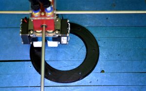 Pracuj blisko drukarki 3d. Drukowanie obiektu drukarki 3D na niebieskim tle. Widok z góry. Filament z tworzywa sztucznego, Nowoczesna technologia druku. Progresywna technologia addytywna