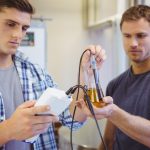 Dwa przypadkowego mężczyzna bada piwo w zlewce