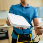 Technik instaluje system bezpieczeństwa w nowoczesnym mieszkaniu