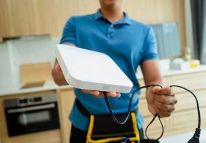 Technik instaluje system bezpieczeństwa w nowoczesnym mieszkaniu