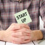 Tekst startowy na kartce papieru w rękach biznesmena