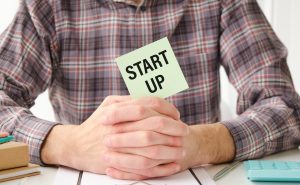 Tekst startowy na kartce papieru w rękach biznesmena