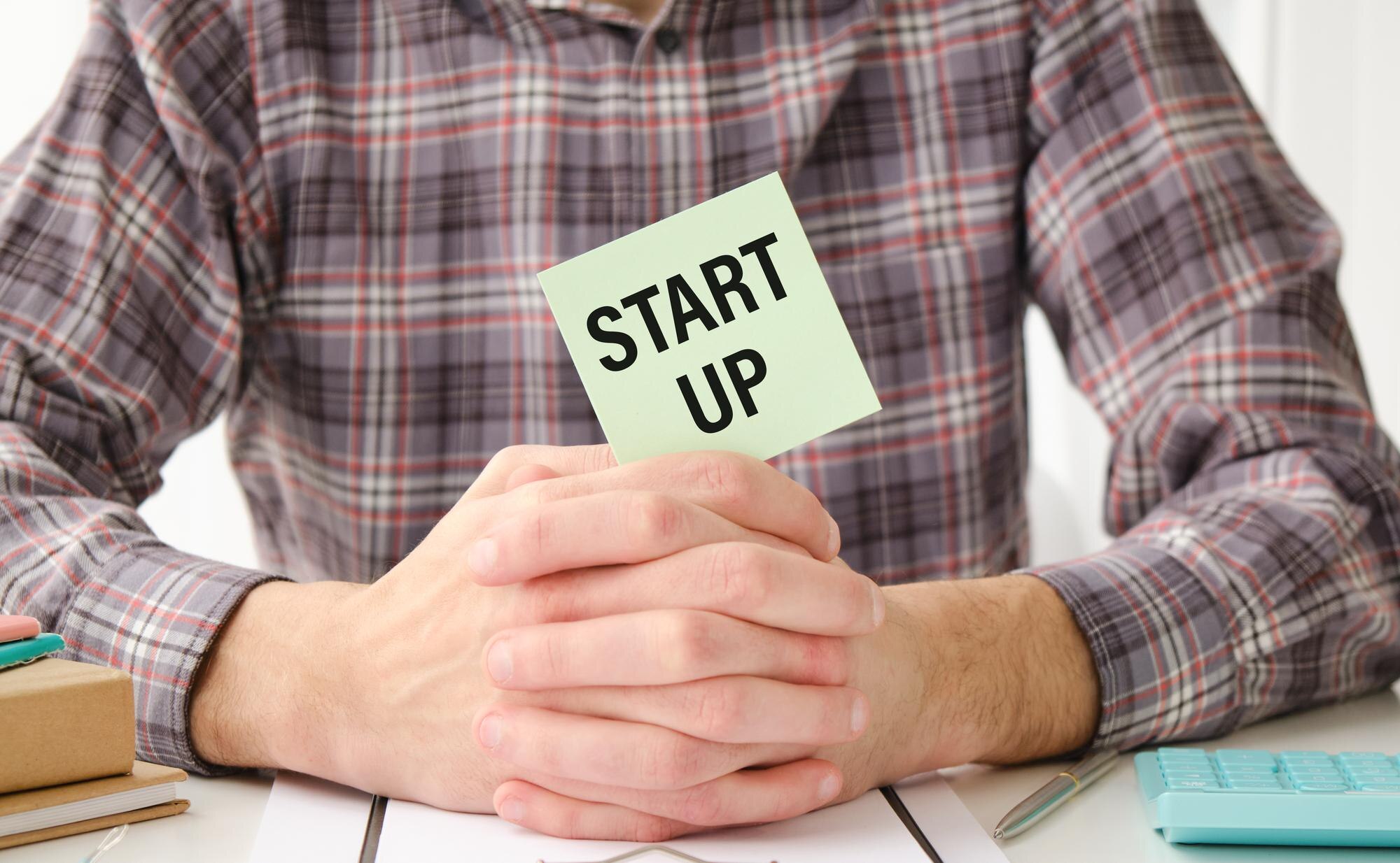 Tekst startowy na kartce papieru w rękach biznesmena