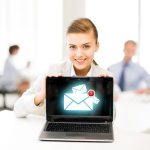 koncepcja biznesowa, komunikacyjna i internetowa - kobieta trzymająca laptopa ze znakiem e-mail