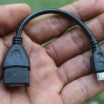 Seseorang sedang memegang kabel usb alat transfer data