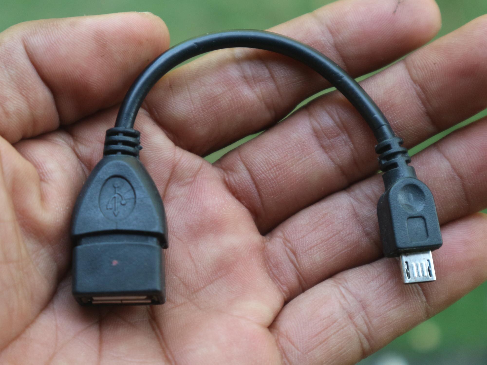 Seseorang sedang memegang kabel usb alat transfer data