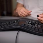 W zbliżeniu widać rękę używającą narzędzia wyciągającego klawisze do skrupulatnego usunięcia klawisza klawiatury