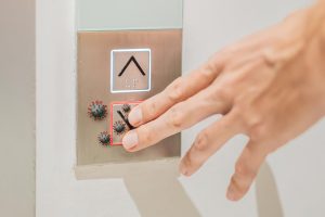 Ręczne naciśnięcie przycisku palca w windzie z wirusem Covid-19 lub koronawirusem w windzie przycisk przycisku z virusem wokół windy lub windy Kontrola infekcji i koncepcja odległości społecznej