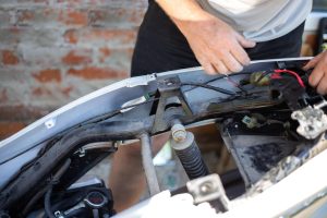 Mężczyzna naprawia motocykl. Zdemontowany motocykl.