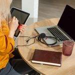 Piękna kaukaska kobieta pracuje na laptopie. Tło kuchnia.