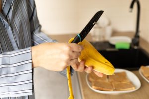 ręce kobiety młoda kobieta łuszczy banan