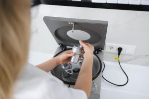 Lekarz kosmetyczka wkłada probówkę do metalowego pojemnika