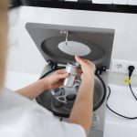 Lekarz kosmetyczka wkłada probówkę do metalowego pojemnika