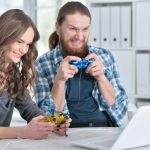 Portret szczęśliwej młodej pary z laptopem gra w domu