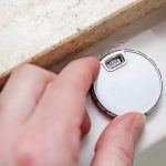 Męska ręka steruje nowoczesną luksusową wanną z hydromasażem i przekręca zawór na wartość MAX