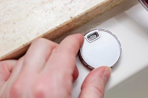 Męska ręka steruje nowoczesną luksusową wanną z hydromasażem i przekręca zawór na wartość MAX