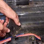 Pracownik serwisowy instaluje materiał dźwiękoszczelny we wnętrzu samochodu