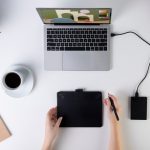 Zbliżenie dłoni z tabletem graficznym