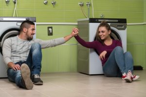 Ładne uśmiechnięte pary w pralni