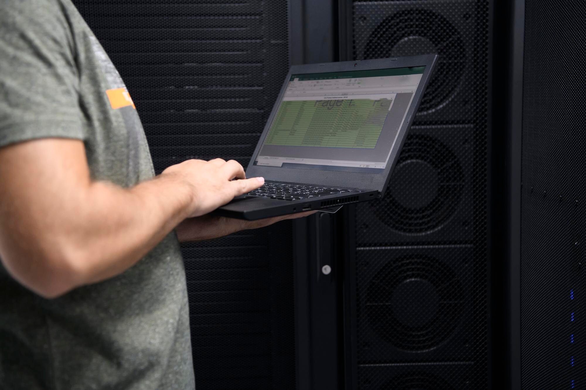 Inżynier centrum danych przy użyciu komputera przenośnego. Specjalista w serwerowni z męskim administratorem systemu pracującym z siecią ochrony danych w celu zapewnienia bezpieczeństwa cybernetycznego lub farmy wydobywczej kryptowalut.