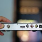 odbiornik satelitarnej pudełko w ręku niewyraźne tło.