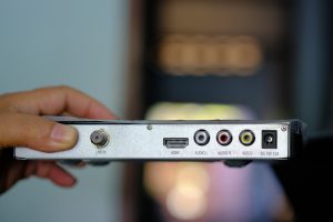 odbiornik satelitarnej pudełko w ręku niewyraźne tło.