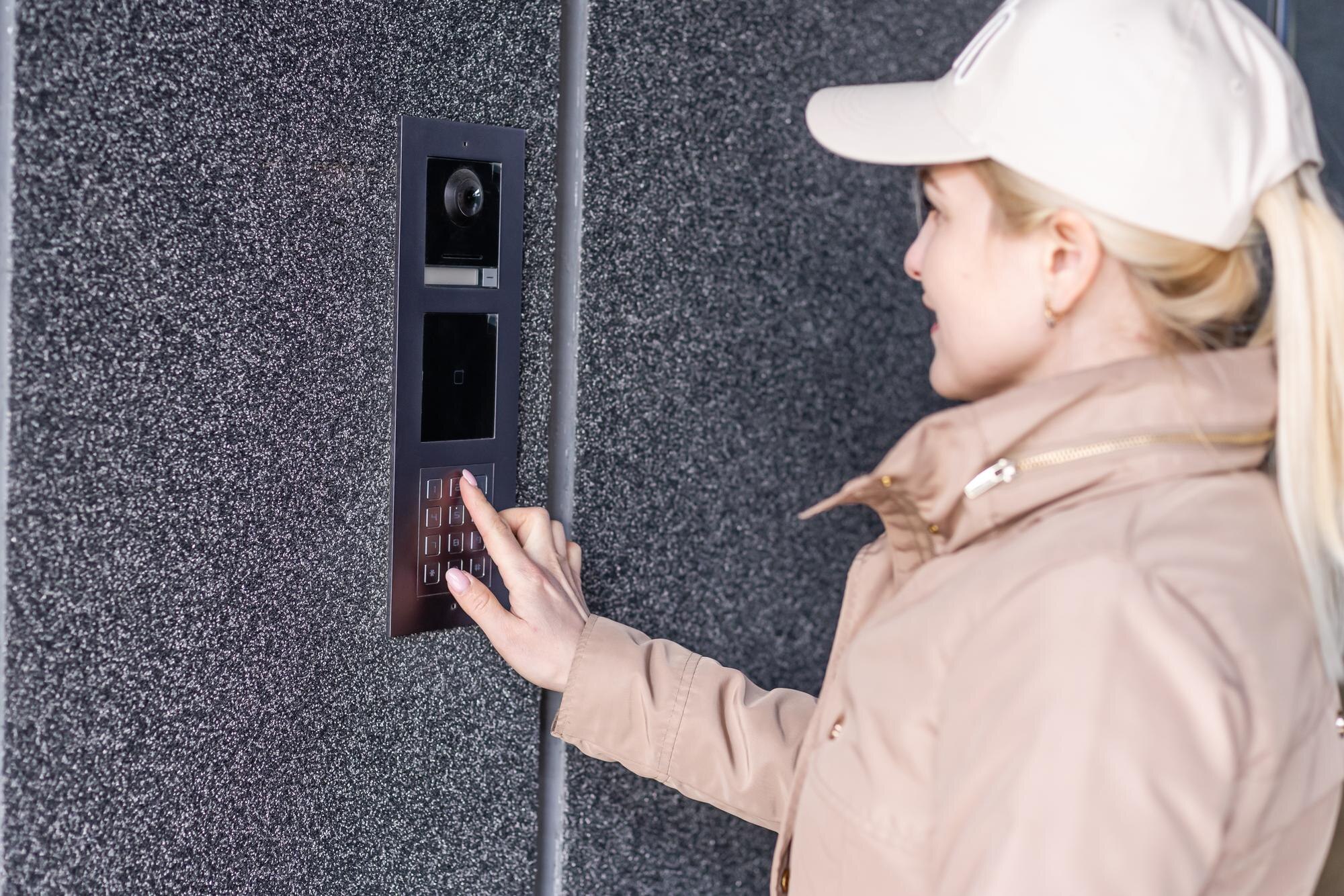 blondynka młoda kobieta w budynku telefon domofon na ulicy.