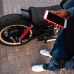 Młody facet trzymający telefon komórkowy na ulicy