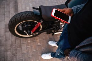 Młody facet trzymający telefon komórkowy na ulicy