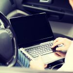 koncepcja transportu i pojazdu - mężczyzna używający laptopa w samochodzie