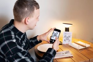 Średni strzał buźkę skanuje qr